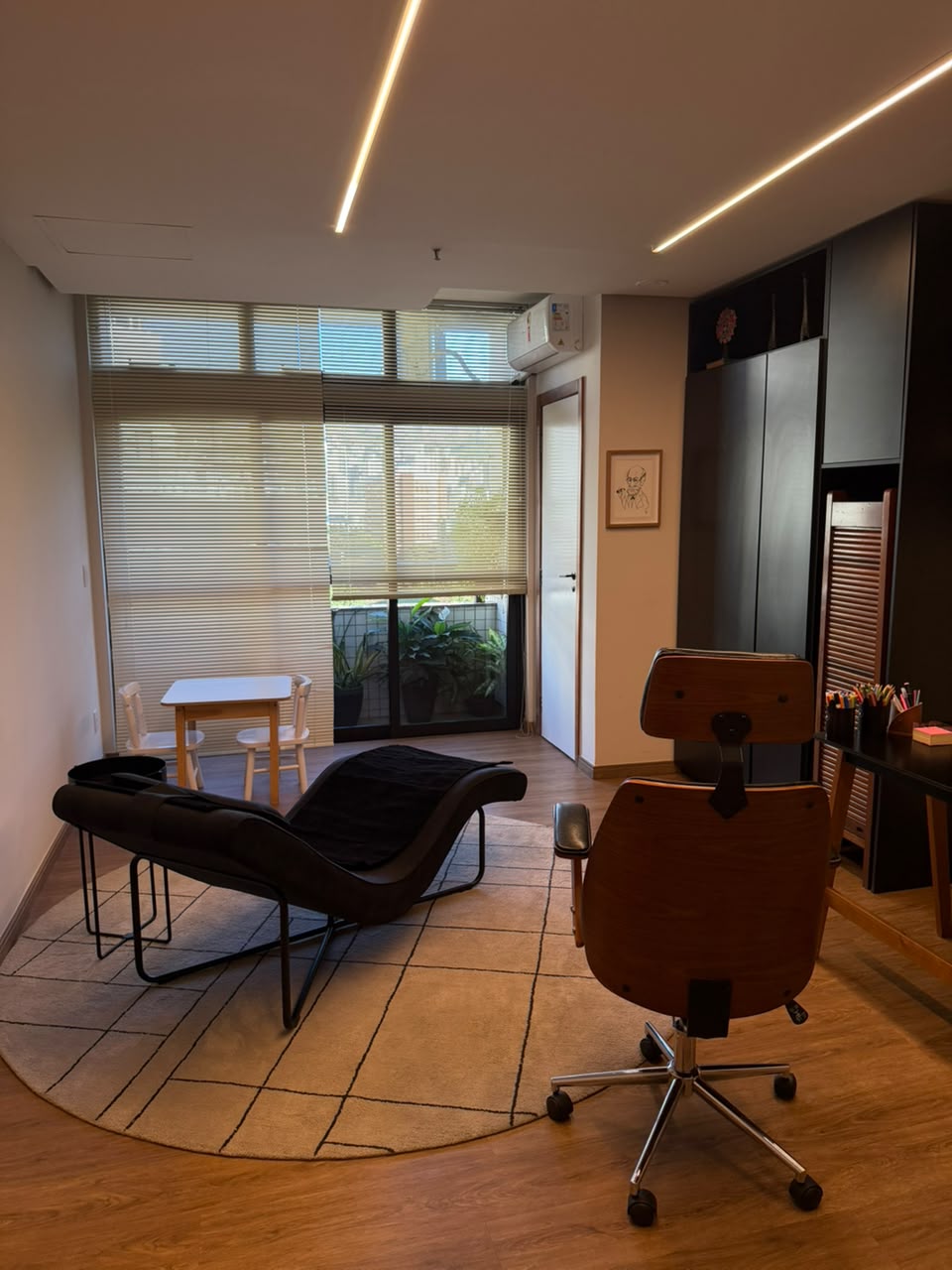 Sala de atendimento com poltrona reclinável, janela com persiana e luz natural