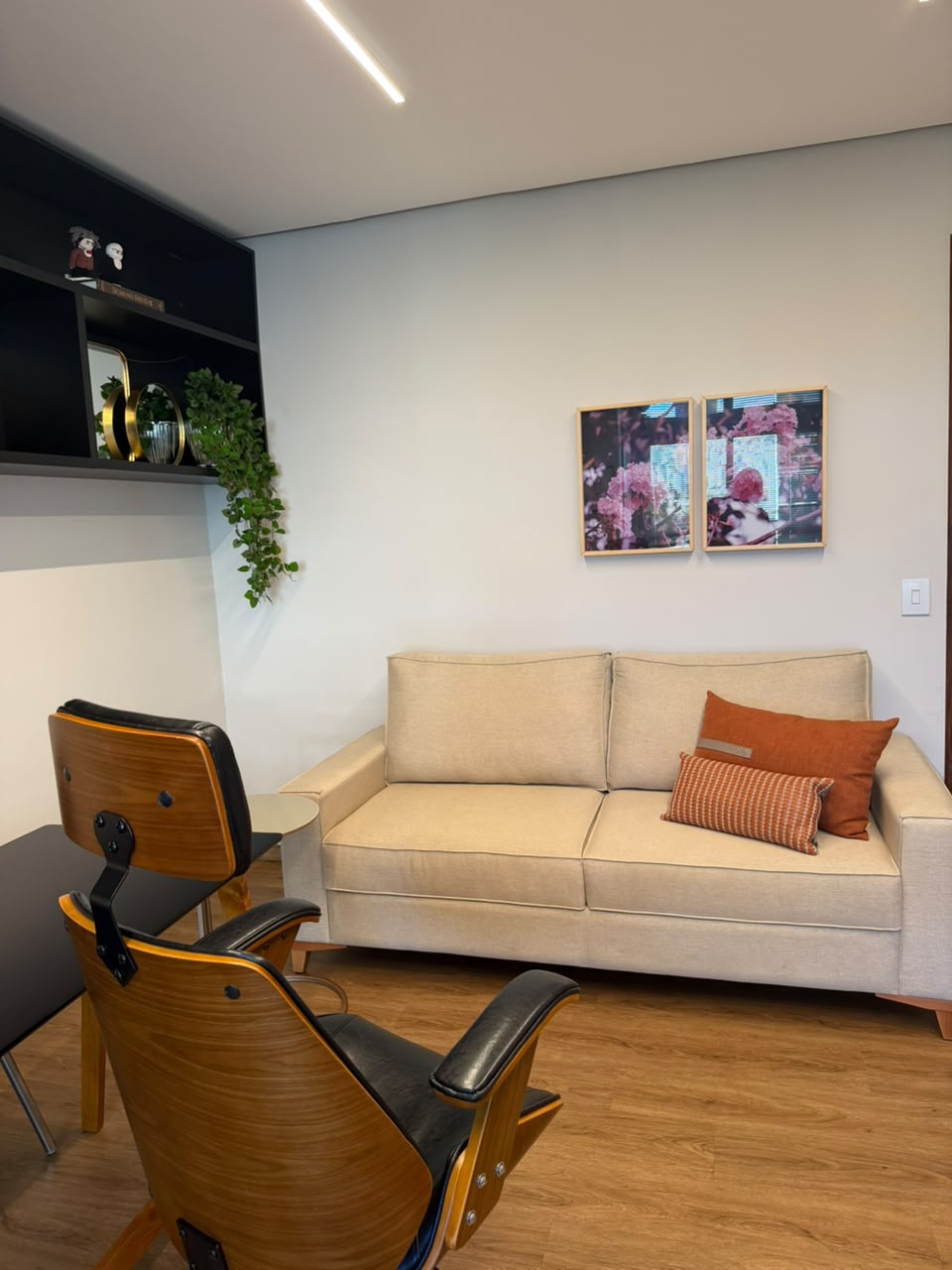 Sala de espera do consultório, com sofá e quadros