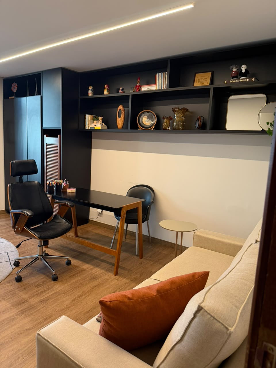 Estante do consultório com livros e mesa de trabalho
